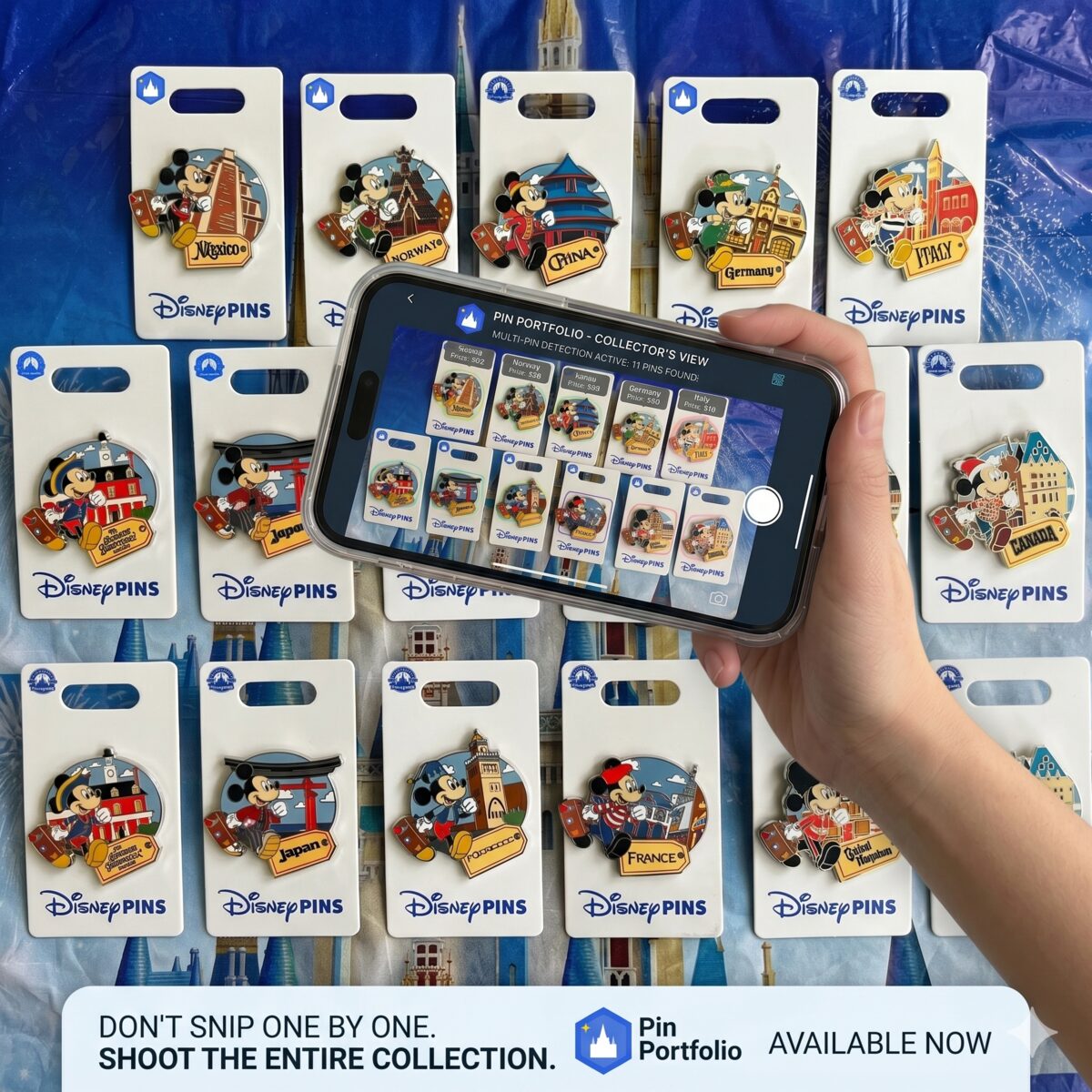 A hand holding a phone running Pin Portfolio, capturing a grid of Disney Traveling Mickey pins laid out on a surface